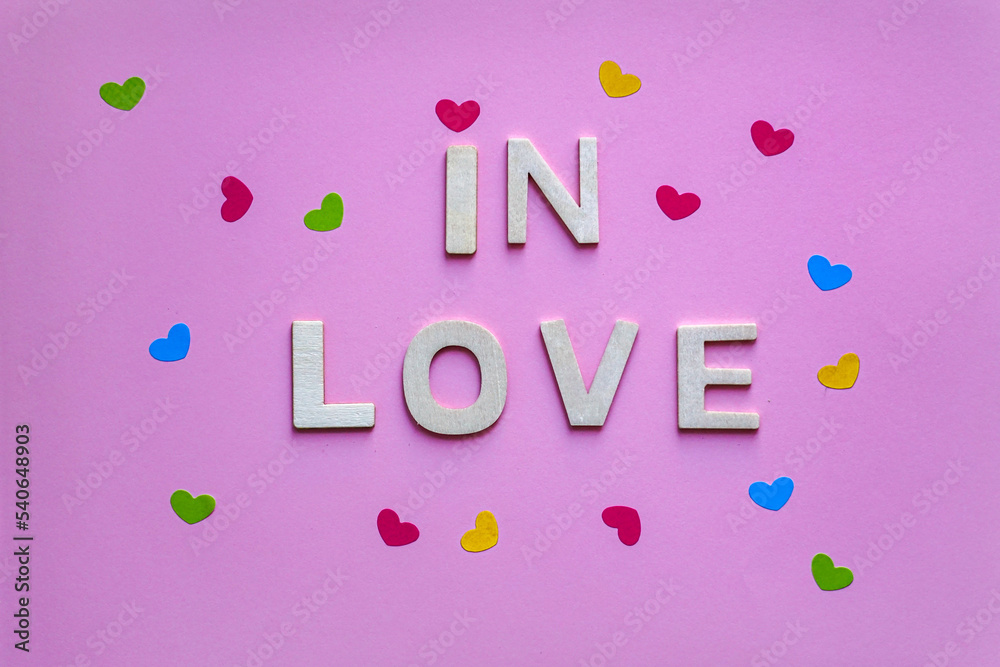 in love word with wooden letters on the pink background, valentine's day