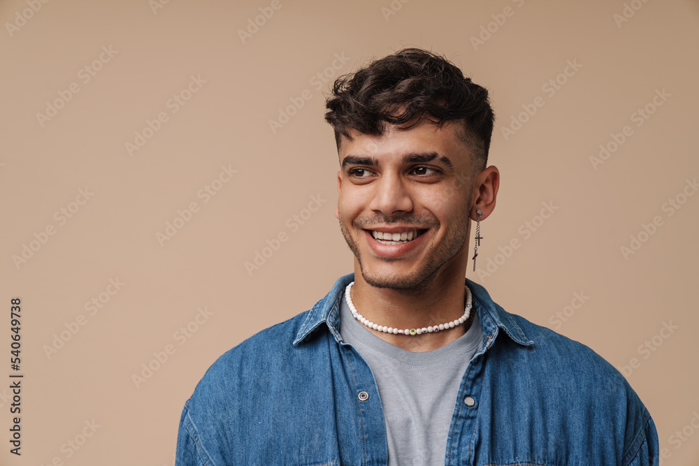 Young handsome stylish happy smiling manwith piercing looking aside