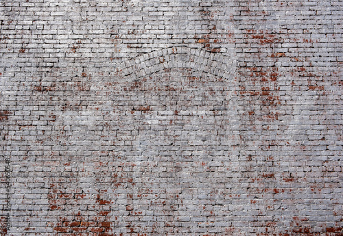 Faded white painted brick wall including brick arch