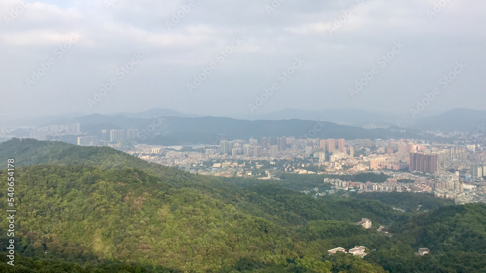 Guangzhou, China, November 2016 - A view of a city with a mountain in the background