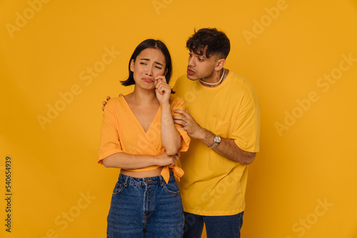 Φωτογραφία Young handsome stylish man consoling asian beautiful sad crying woman
