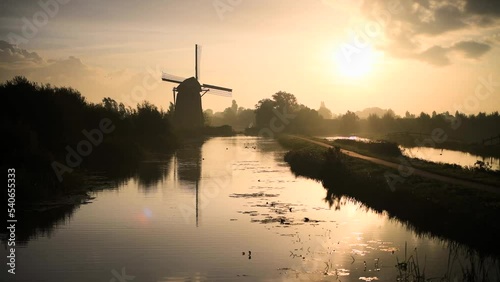 Calm and foggy golden sunrise morning on the Hazerswouder-Dorp windmill,  Rietveldse, Netherlands. photo