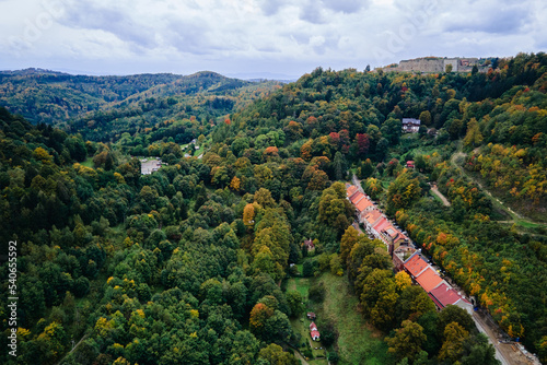 Drone flight over countryside with mountain village and agricultural fields at autumn season. Autumn nature landscape