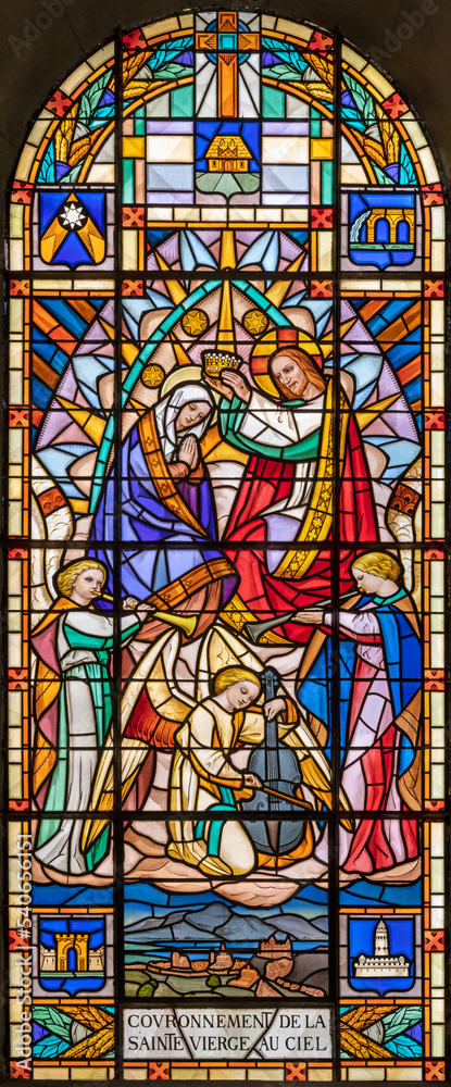 ANNEC, FRANCE - JULY 11, 2022: The  Coronation of Virgin Mary in the stained glass of church Notre Dame de Lellis by L. Balmet (1933).