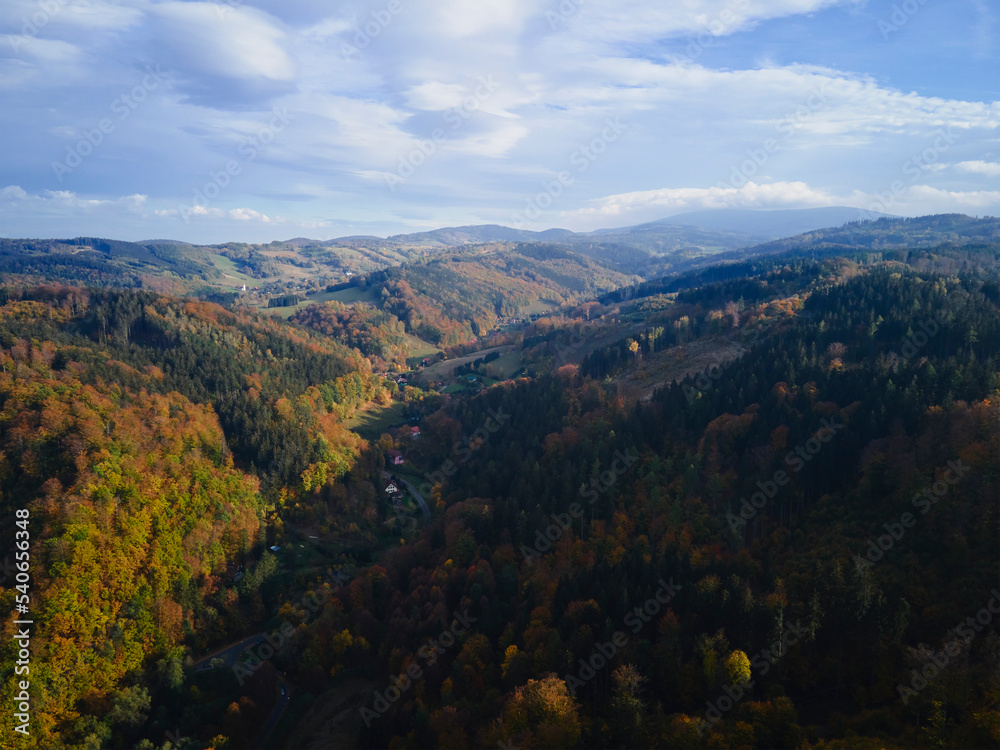 Drone flight over mountains covered with forest at autumn season. Beautiful nature landscape