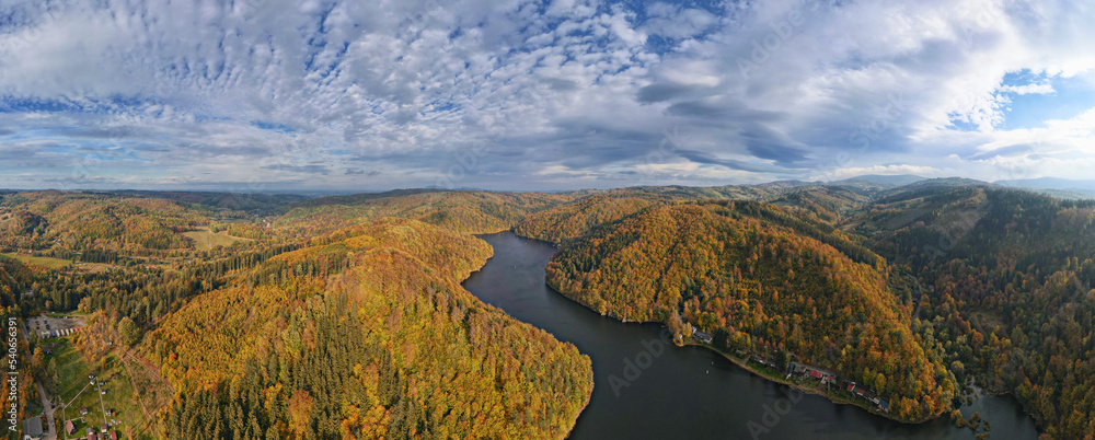 Fototapeta premium Aerial top view of amazing autumn landscape with mountains covered with forest and river. Beautiful nature landscape panorama at fall season