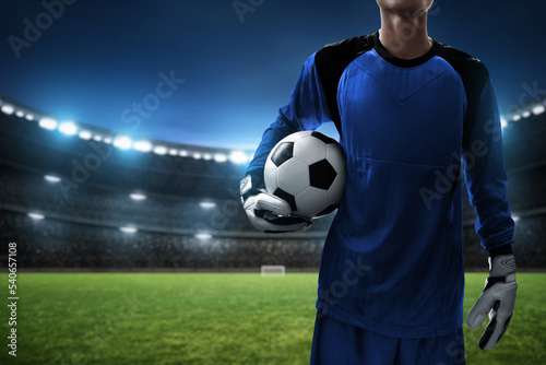 Soccer goalkeeper holding ball in the stadium