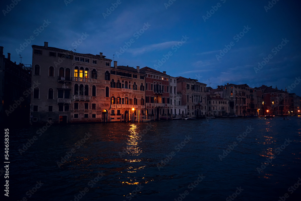 Venice deep evening night landscape with the view of venetian houses with luminous windows on the Grand canal