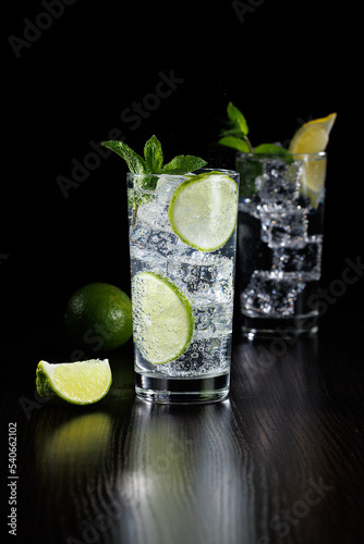 Mojito or virgin mojito long rum drink with fresh mint, lime juice, cane sugar and soda. Black background.