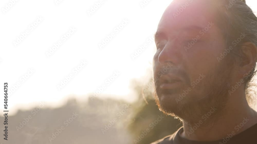 Man smoking marijuana, weed, joint, getting high, sunshine, smoke. 4K 24FPS.