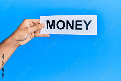Hand of caucasian man holding paper with money word over isolated blue background