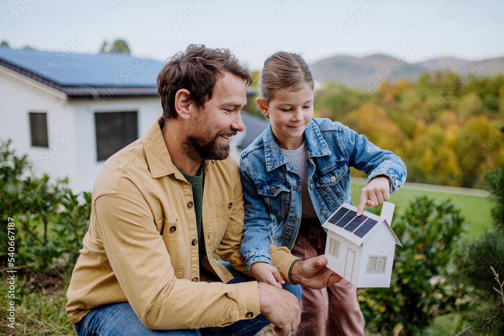 © Halfpoint - Little girl with her dad holding paper model of house with solar panels, explaining how it works.Alternative energy, saving resources and sustainable lifestyle concept. © Halfpoint - Little girl with her dad holding paper model of house with solar panels, explaining how it works.Alternative energy, saving resources and sustainable lifestyle concept.