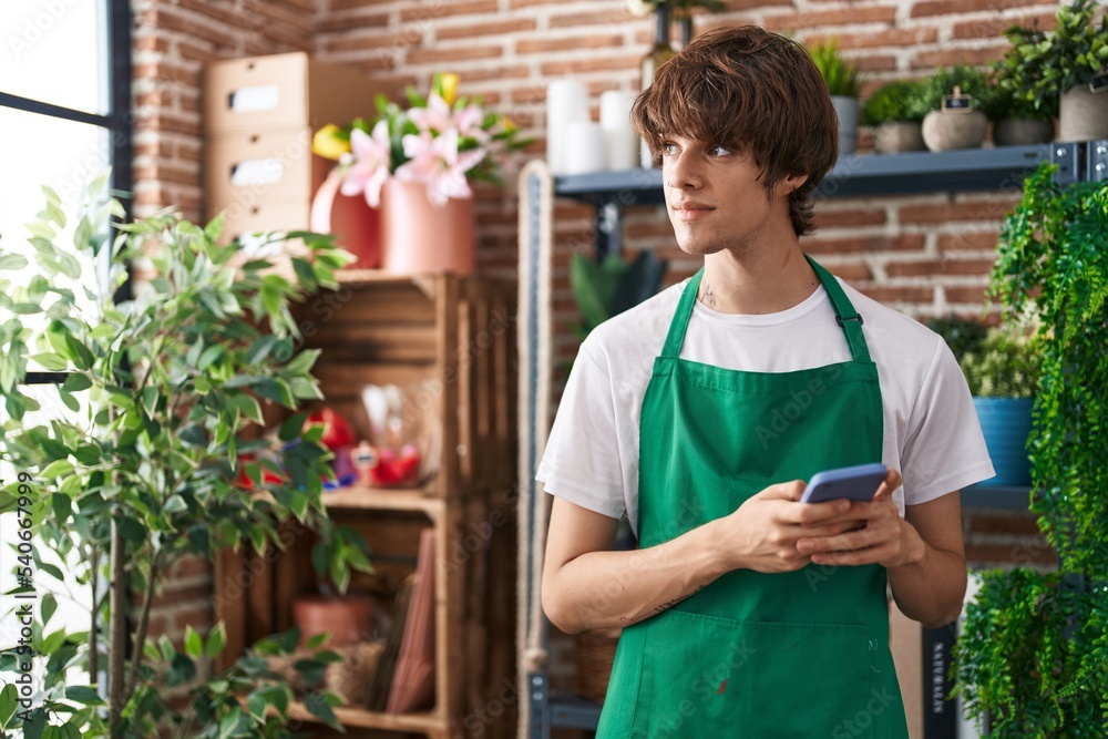 Young blond man florist using smartphone at flower shop Young blond man florist using smartphone at flower shop
