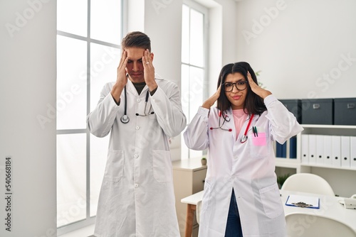 Young doctors wearing uniform and stethoscope at the clinic with hand on head  headache because stress. suffering migraine.