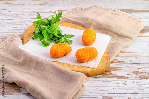 croquettes on paper on a wooden board