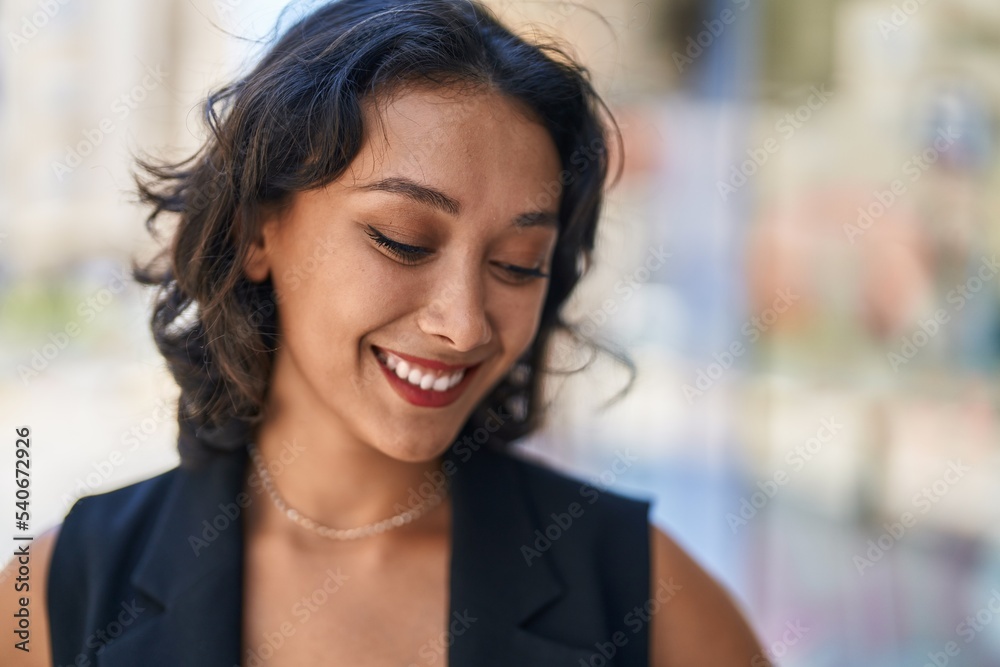 Young beautiful hispanic woman smiling confident looking to the side at street Young beautiful hispanic woman smiling confident looking to the side at street