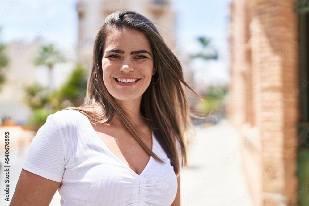 Young woman smiling confident looking to the camera at street Young woman smiling confident looking to the camera at street
