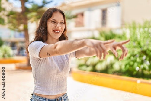 Young woman smiling confident pointing with fingers at park