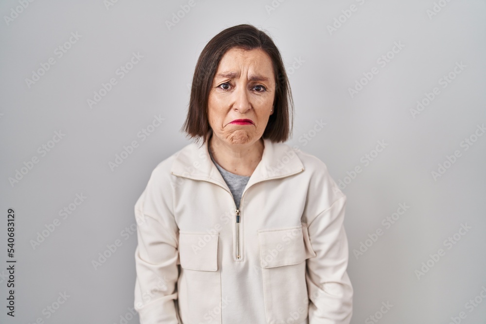 Obraz premium Middle age hispanic woman standing over isolated background depressed and worry for distress, crying angry and afraid. sad expression.