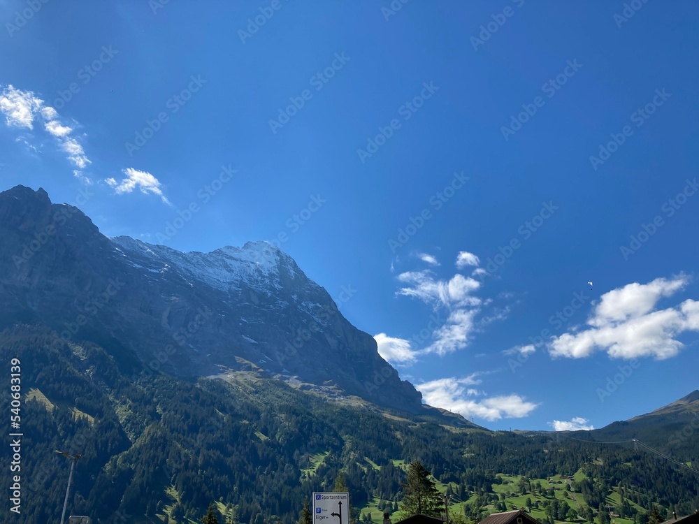 Summer day blue sky mountains landscape. Nature landscape with sun and blue sky. Summer travel in Europe mountains. Nature, lake, forest, trees hiking path. Clouds on blue sky. Forest landscape hiking