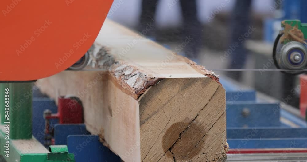 Work of the sawmill in close-up. Process of machining logs in equipment sawmill machine saw saws the tree trunk on the plank boards.