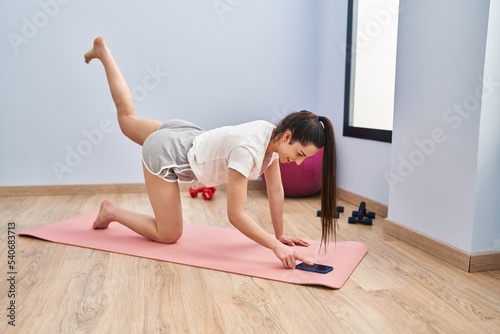 Young beautiful hispanic woman smiling confident training legs exercise at sport center