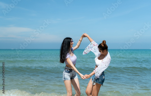 LGBT couples traveling around Asia, Swim happily on the sandy beach with the beautiful blue sea