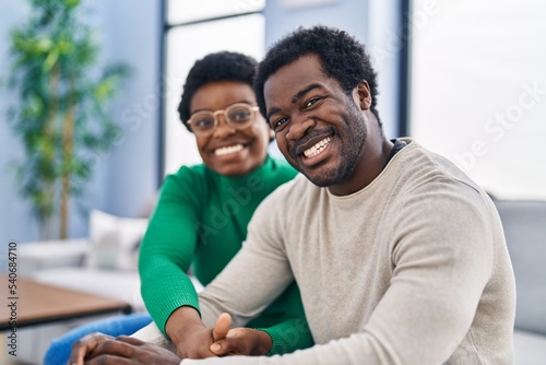 African american man and woman couple smiling confident sitting together at home