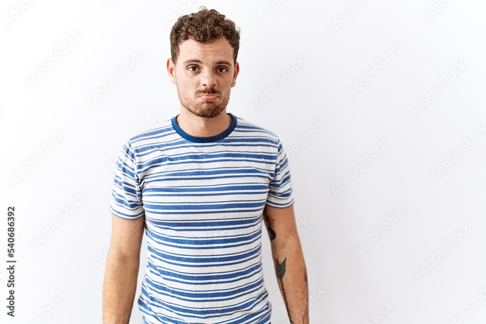 Handsome young man standing over isolated background depressed and worry for distress, crying angry and afraid. sad expression.