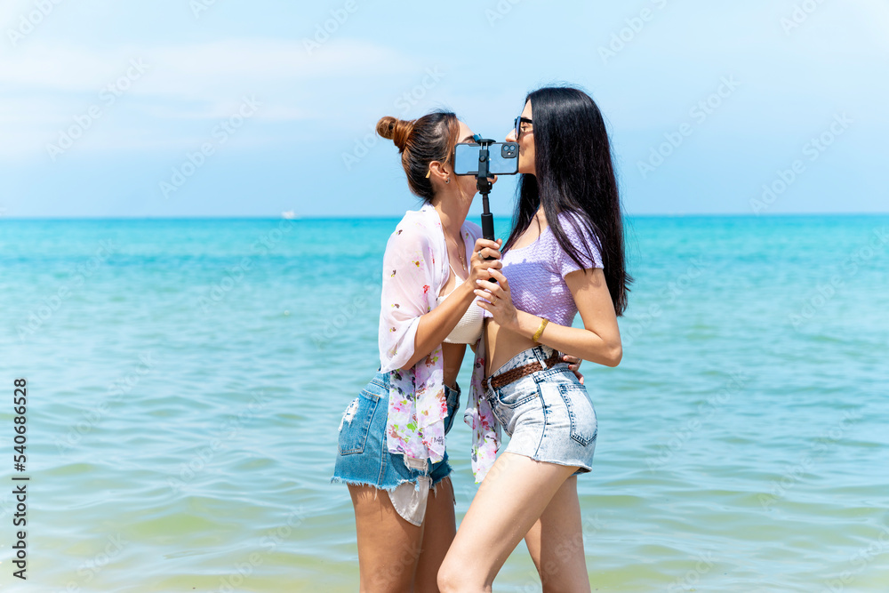 LGBTQ lesbian couple on the beach The couple went to the sea on vacation together happily. LGBTQ lesbian couple on the beach The couple went to the sea on vacation together happily.