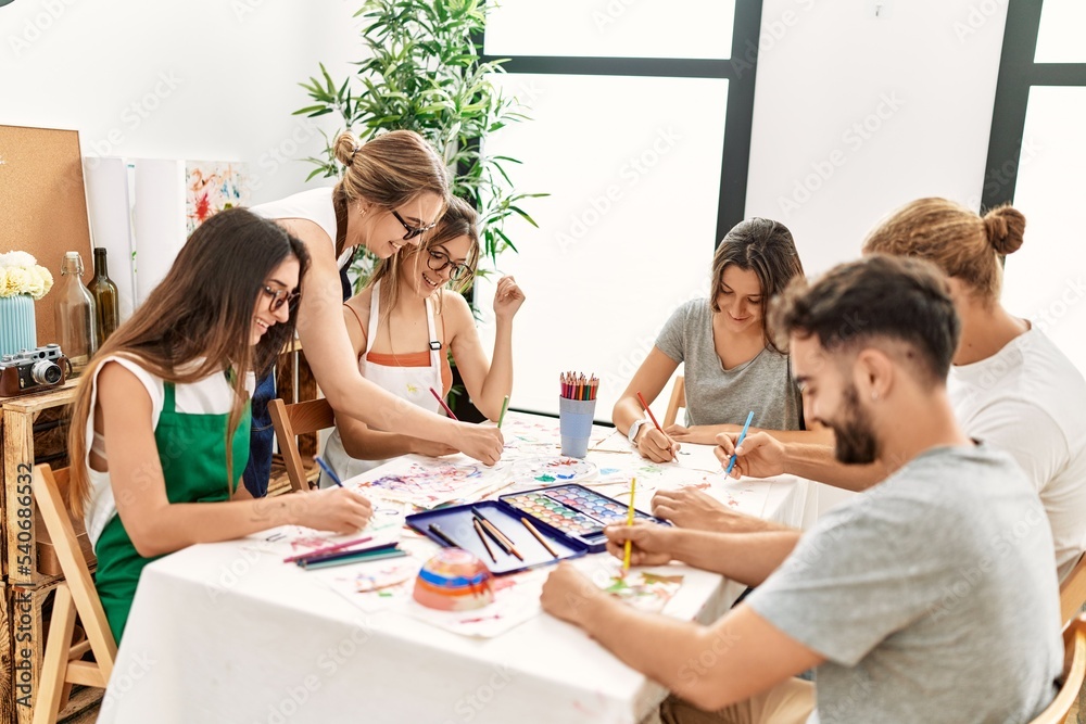 Group of young paint students smiling happy and drawing sitting on the table at art studio. Group of young paint students smiling happy and drawing sitting on the table at art studio.
