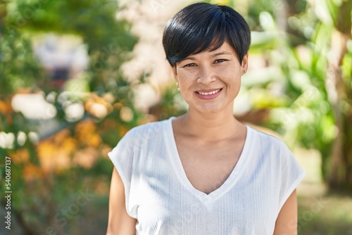 Middle age chinese woman smiling confident standing at park