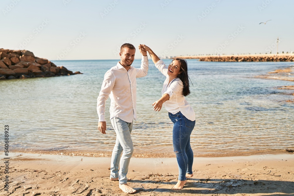 Man and woman couple smiling happy dancing at seaside Man and woman couple smiling happy dancing at seaside