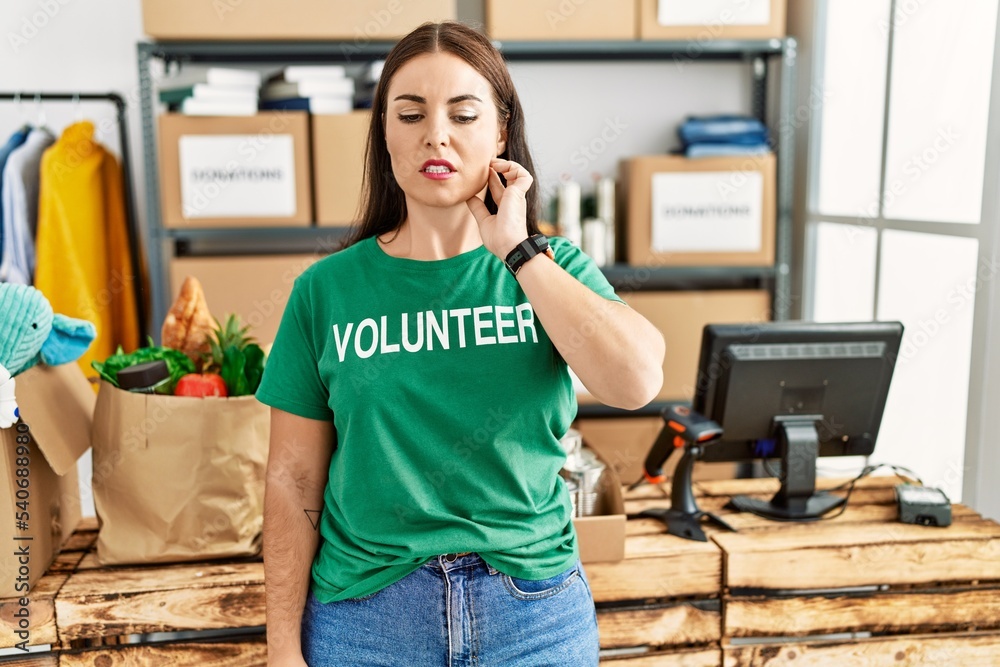 Young brunette woman wearing volunteer t shirt at donations stand touching mouth with hand with painful expression because of toothache or dental illness on teeth. dentist concept. Young brunette woman wearing volunteer t shirt at donations stand touching mouth with hand with painful expression because of toothache or dental illness on teeth. dentist concept.