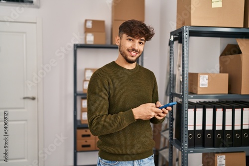Young arab man ecommerce business worker using smartphone at office