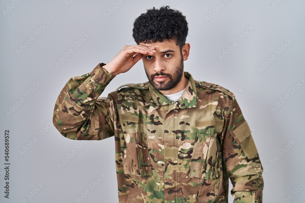 Arab man wearing camouflage army uniform worried and stressed about a problem with hand on forehead, nervous and anxious for crisis