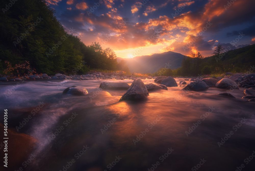 Magical sunset over fast flowing mountain river