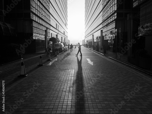 Silhouette of pedestrian under sunset in downtown district