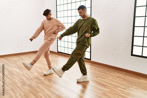 Two hispanic men couple dancers smiling confident dancing at sport center