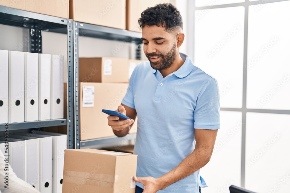Young hispanic man ecommerce business worker make photo to package at office