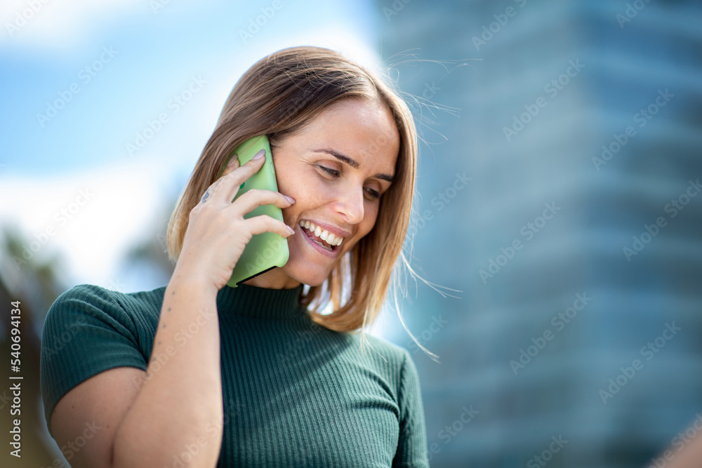 Fototapeta premium Close up= woman talking with mobile phone in city