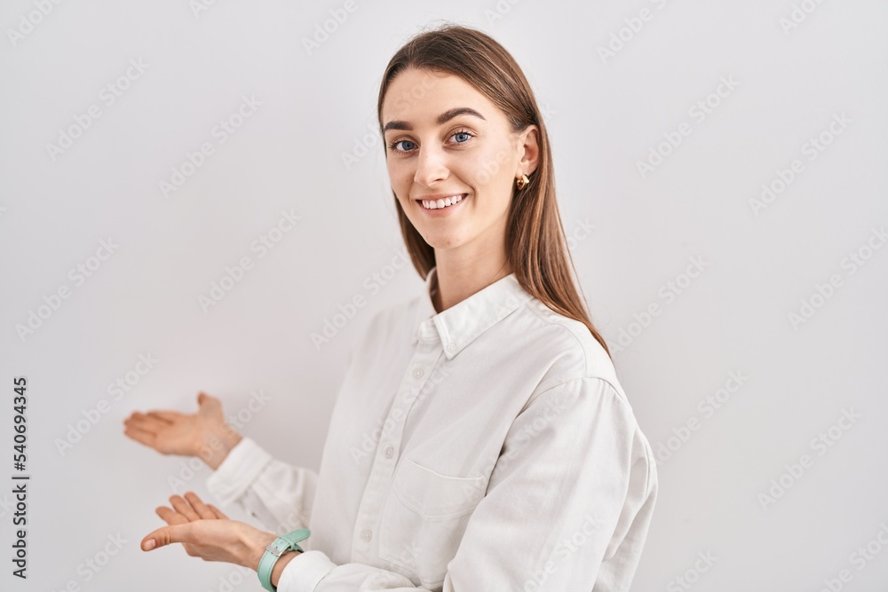 Young caucasian woman standing over isolated background inviting to enter smiling natural with open hand Young caucasian woman standing over isolated background inviting to enter smiling natural with open hand