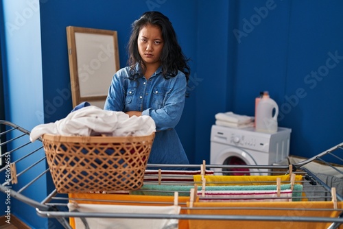 Young asian woman hanging clothes at clothesline skeptic and nervous, frowning upset because of problem. negative person.