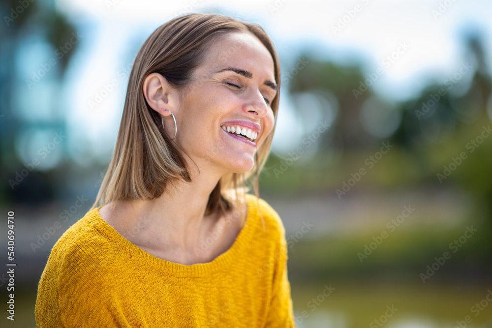 Close up happy woman laughing outdoors