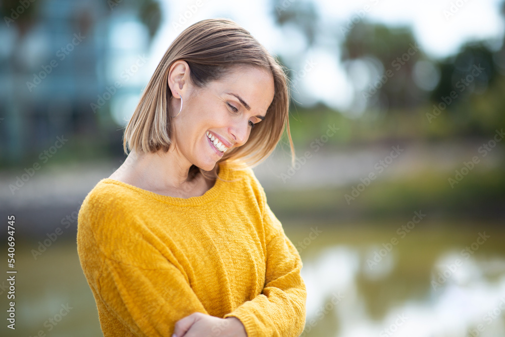 Close up side of beautiful woman laughing outdoors Close up side of beautiful woman laughing outdoors