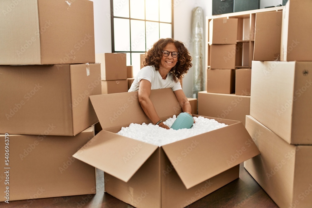 Fototapeta premium Middle age hispanic woman smiling confident moving at new home