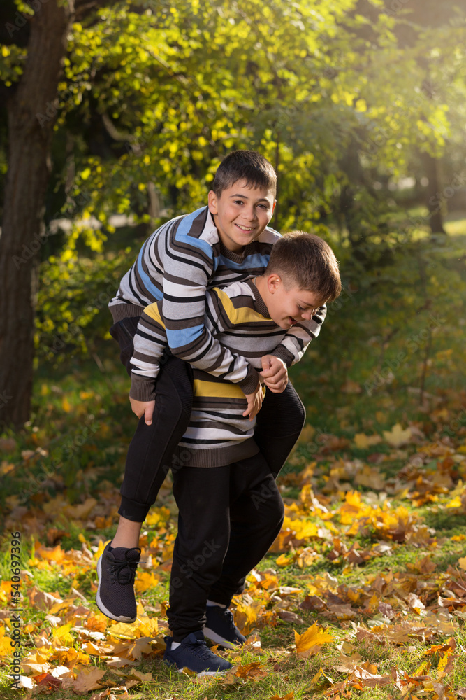 Fototapeta premium Children, two boys have fun in the park in autumn, outdoor activities, lifestyle