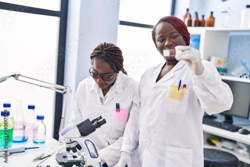 African american women doctor and patient using touchpad having consultation at laboratory