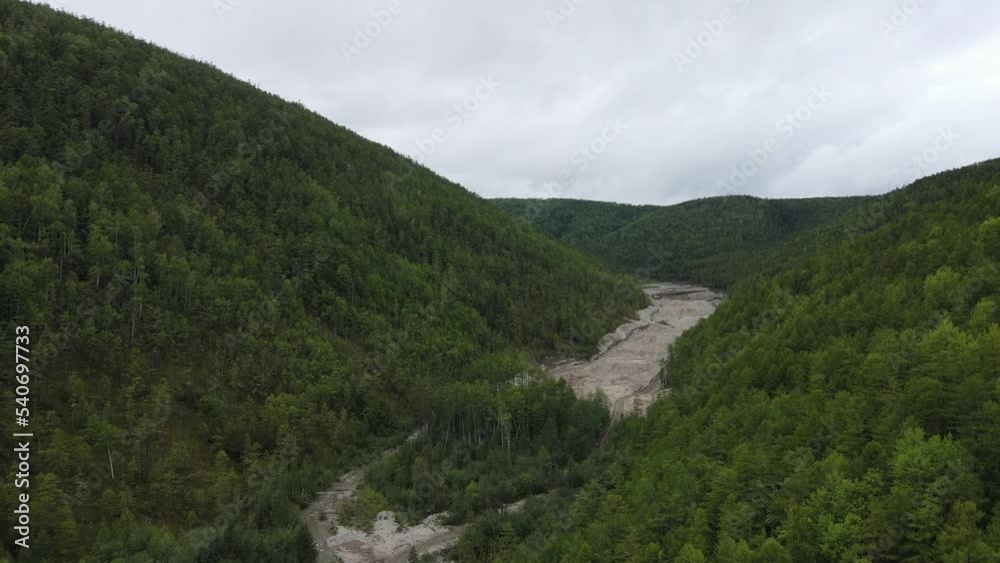 View from above. Industrial mining of alluvial gold in the protected river. The river destroyed by the prospectors is in the ravine. View from above. Industrial mining of alluvial gold in the protected river. The river destroyed by the prospectors is in the ravine.