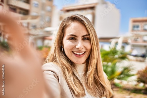 Young blonde woman smiling confident make selfie by the smartphone at street © Krakenimages.com